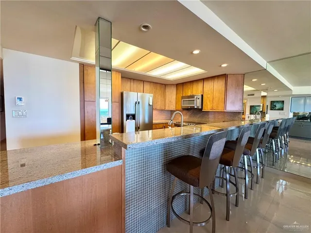 a kitchen with stainless steel appliances granite countertop table chairs sink and cabinets