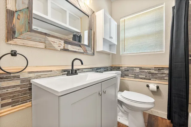 a bathroom with a toilet a sink and a mirror