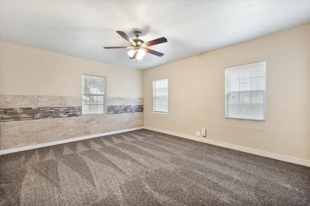 a view of a livingroom with a ceiling fan and window