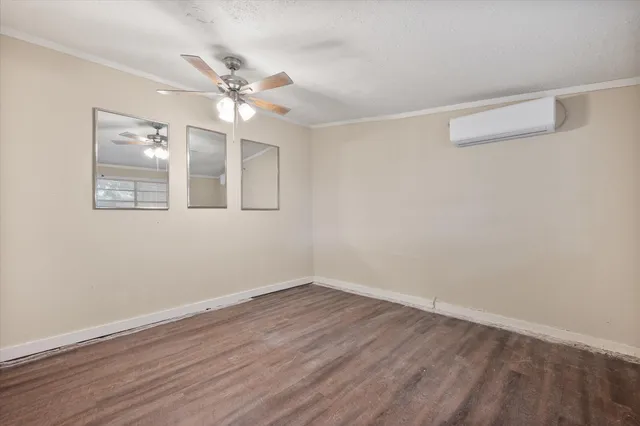 a view of an empty room with wooden floor