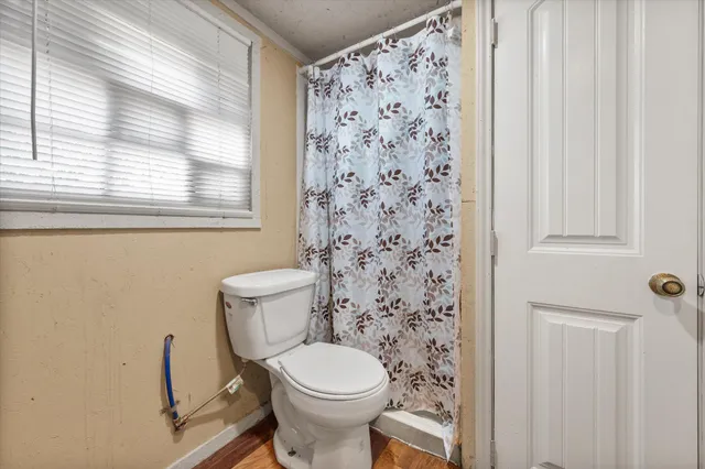 a white toilet sitting next to a shower curtain