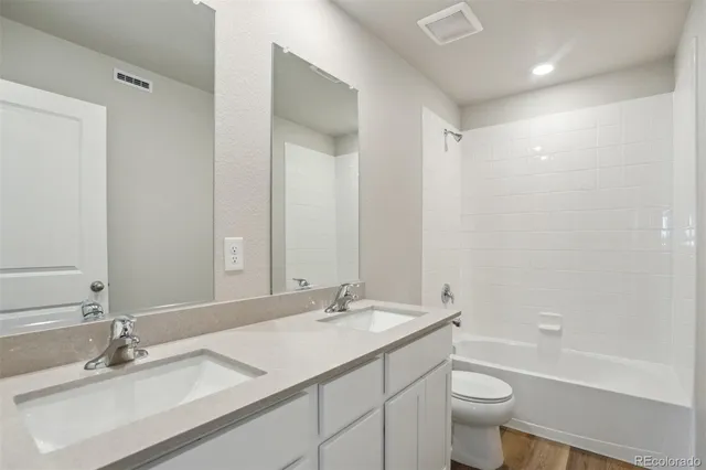 a bathroom with a granite countertop sink a toilet and a bathtub