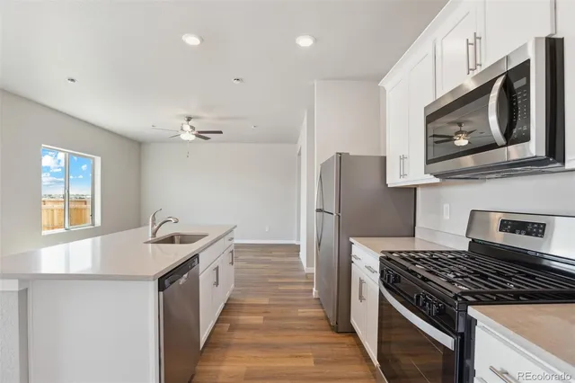 a kitchen with stainless steel appliances granite countertop a stove a sink and a microwave