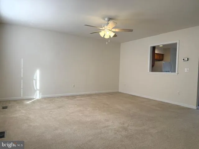 a view of an empty room with a chandelier fan