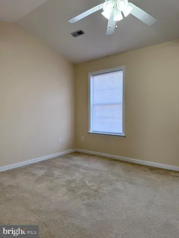 an empty room with a chandelier fan