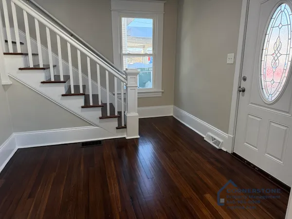 a view of a hallway with wooden floor and staircase