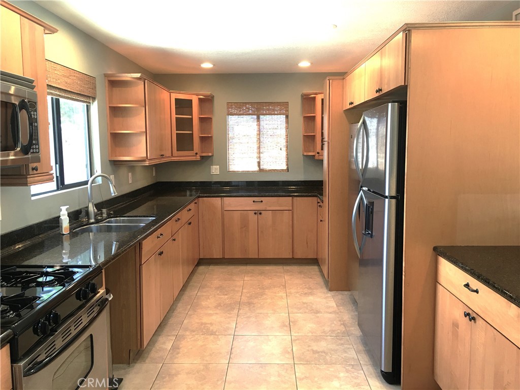 10011 Bernice Circle Buena Park, CA 90620 - Photo 4 of 28 a large kitchen with stainless steel appliances granite countertop a stove a sink and a refrigerator