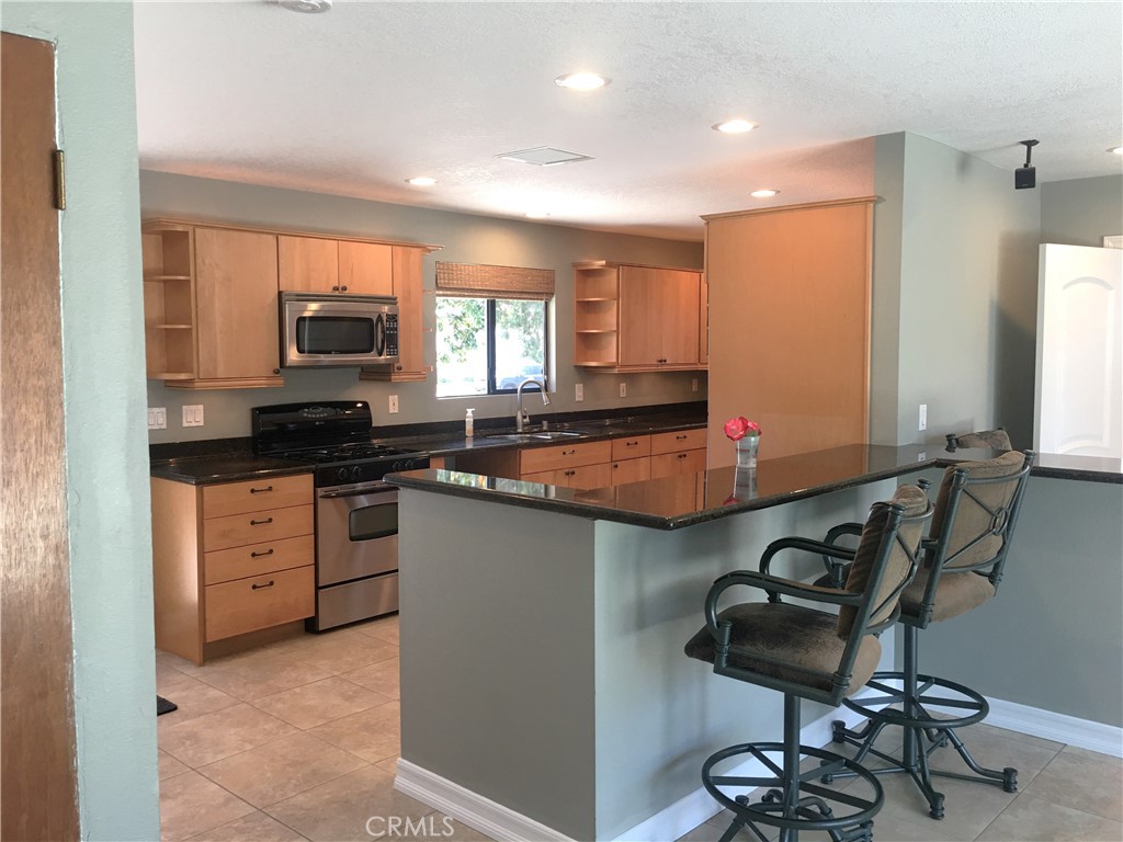 10011 Bernice Circle Buena Park, CA 90620 - Photo 6 of 28 a kitchen with kitchen island granite countertop a sink cabinets and window
