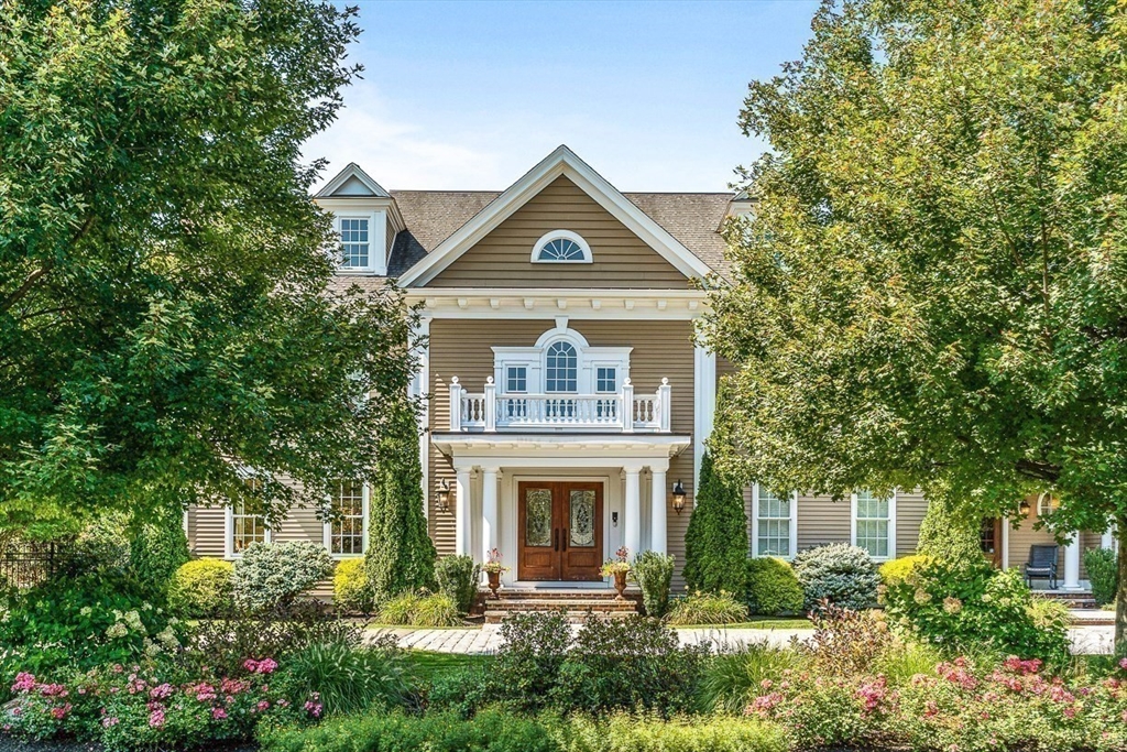 a front view of a house with a yard and potted plants