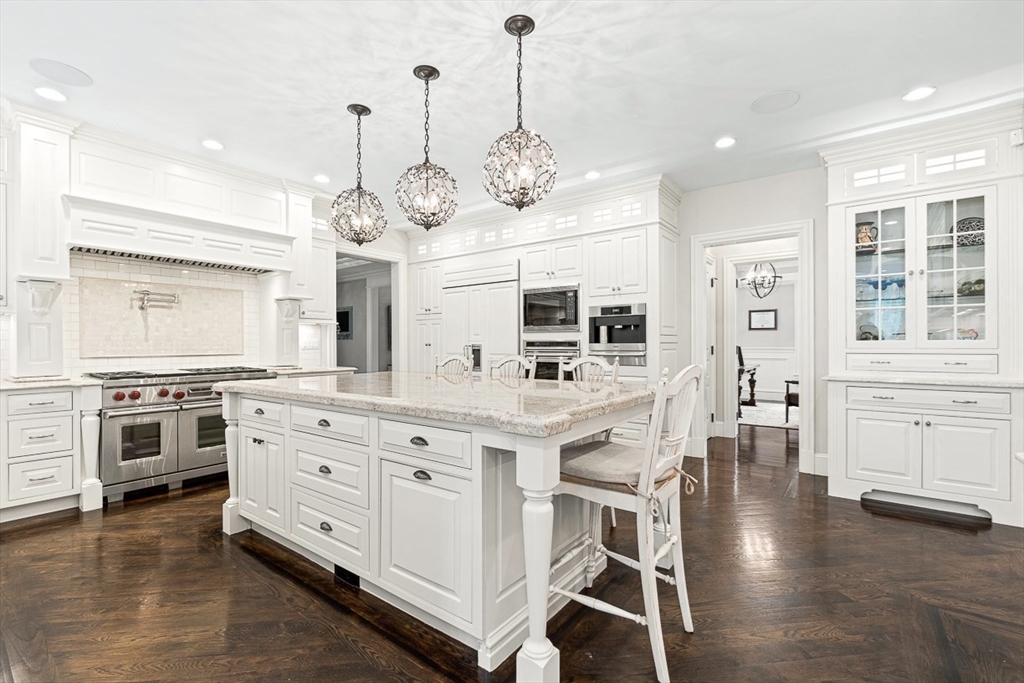 11 Village Lane Needham, MA 02492 - Photo 12 of 42 a kitchen with stainless steel appliances kitchen island granite countertop a stove and cabinets with wooden floor