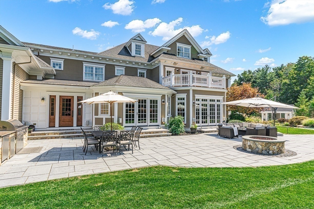 11 Village Lane Needham, MA 02492 - Photo 33 of 42 a front view of a house with a yard table and chairs