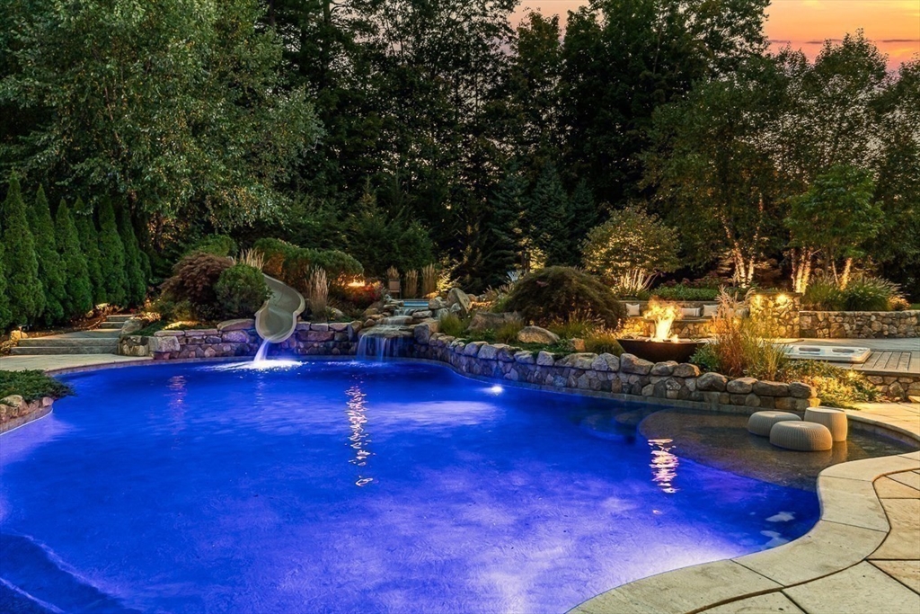 11 Village Lane Needham, MA 02492 - Photo 38 of 42 a view of a swimming pool with lawn chairs under an umbrella