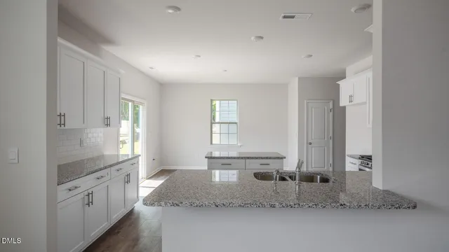 a kitchen with granite countertop stainless steel appliances and white cabinets