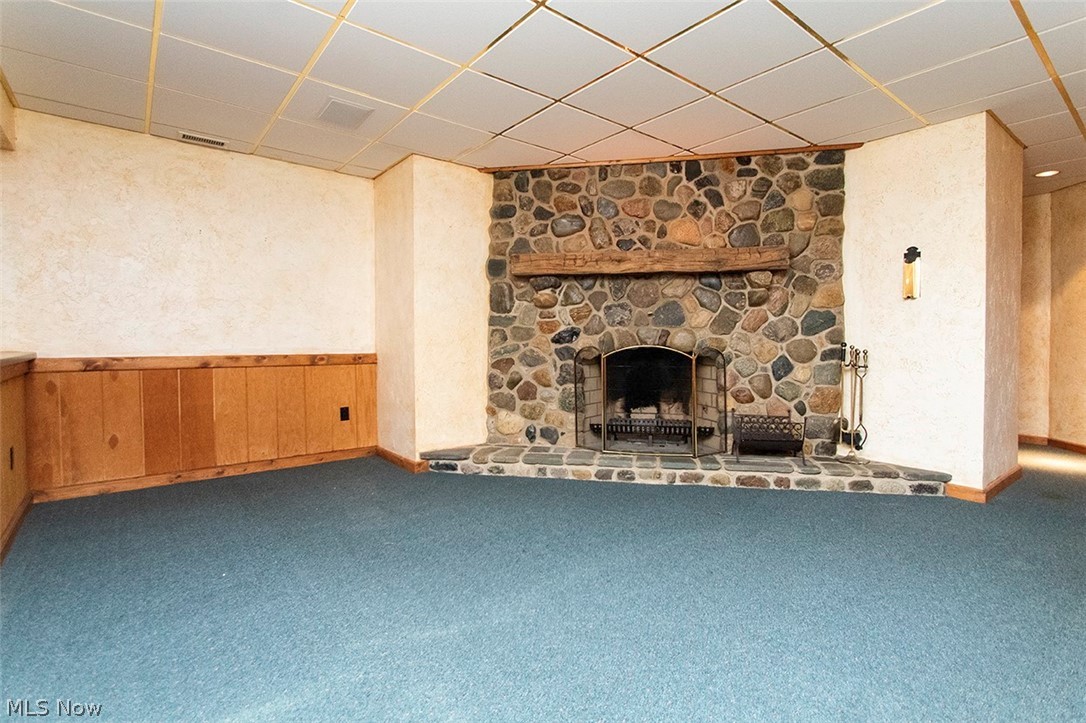 1871 Mattingly Road Hinckley, OH 44233 - Photo 39 of 50 Unfurnished family room with a drop ceiling, a fireplace, carpet floors, wood walls, and wainscoting