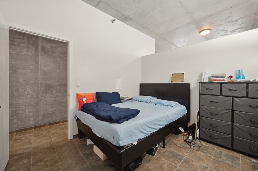 235 West Van Buren Street, Unit 1506 Chicago, IL 60607 - Photo 7 of 16 a bedroom with a bed and dresser