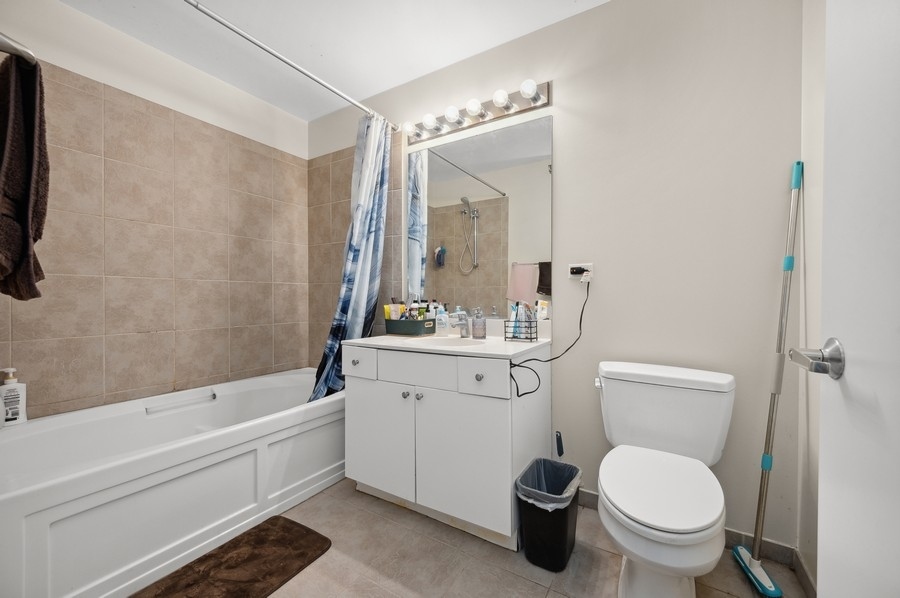 235 West Van Buren Street, Unit 1506 Chicago, IL 60607 - Photo 8 of 16 a bathroom with a granite countertop toilet a sink and a bathtub