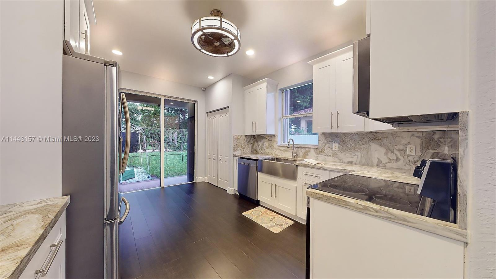 2231 Northeast 37th Road Homestead, FL 33033 - Photo 12 of 49 a kitchen with a stove a sink and a refrigerator