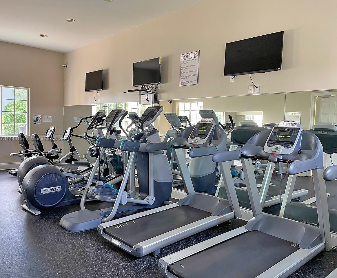 2231 Northeast 37th Road Homestead, FL 33033 - Photo 45 of 49 a room with gym equipment and a flat screen tv