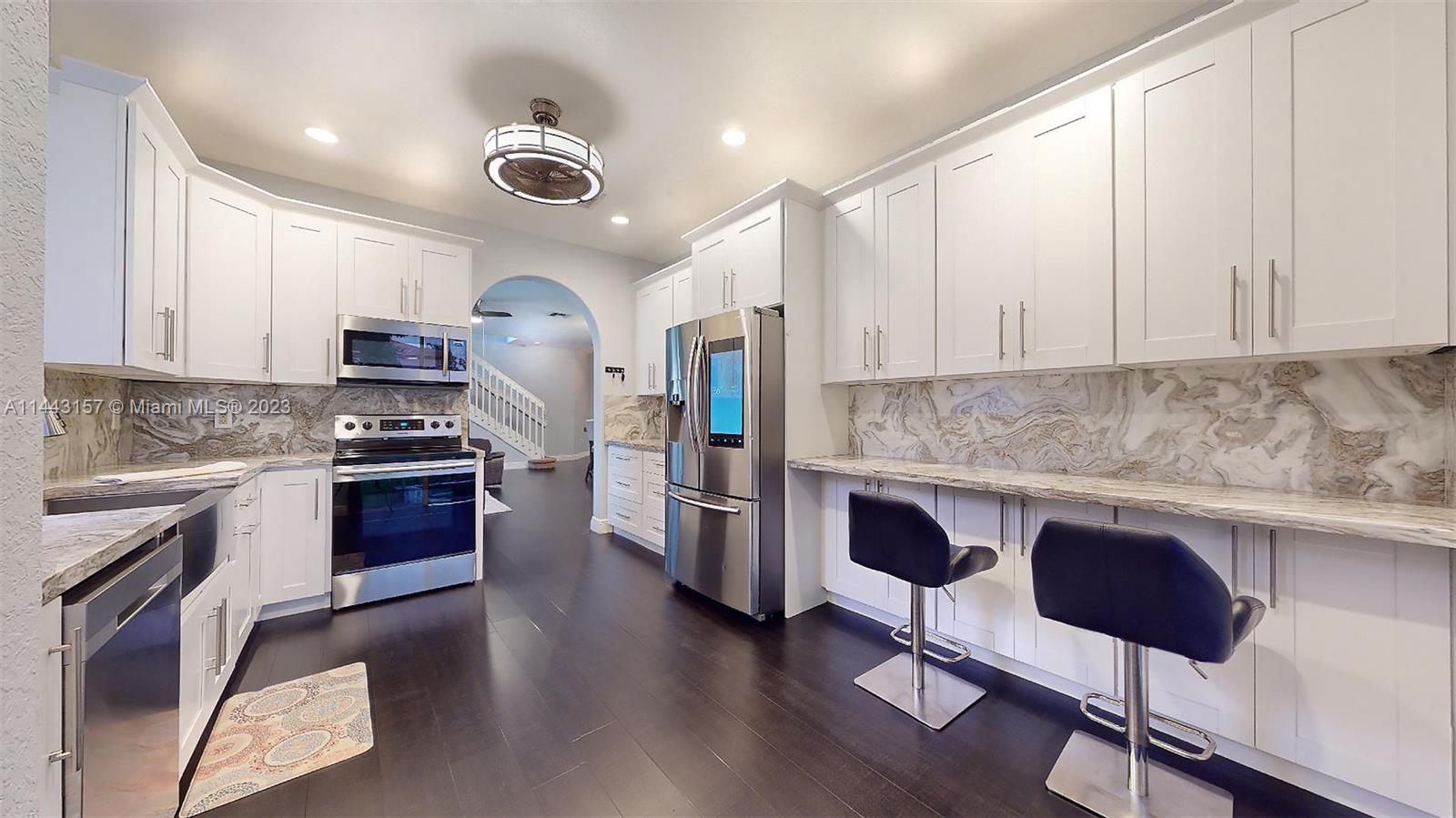 2231 Northeast 37th Road Homestead, FL 33033 - Photo 10 of 49 a kitchen with stainless steel appliances granite countertop a stove a sink dishwasher and a refrigerator with wooden floor