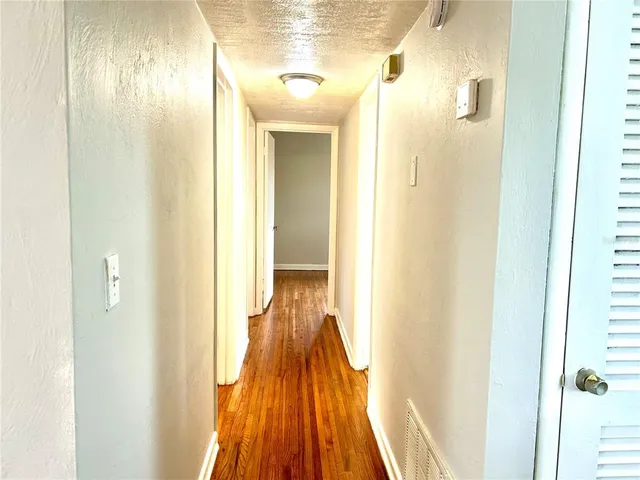 a view of a hallway with wooden floor