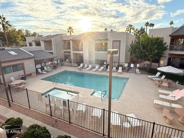 a balcony with table and chairs and potted plants