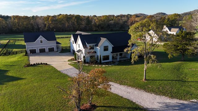 an aerial view of a house with swimming pool lawn chairs and a yard