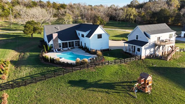 a view of a house with swimming pool and a yard