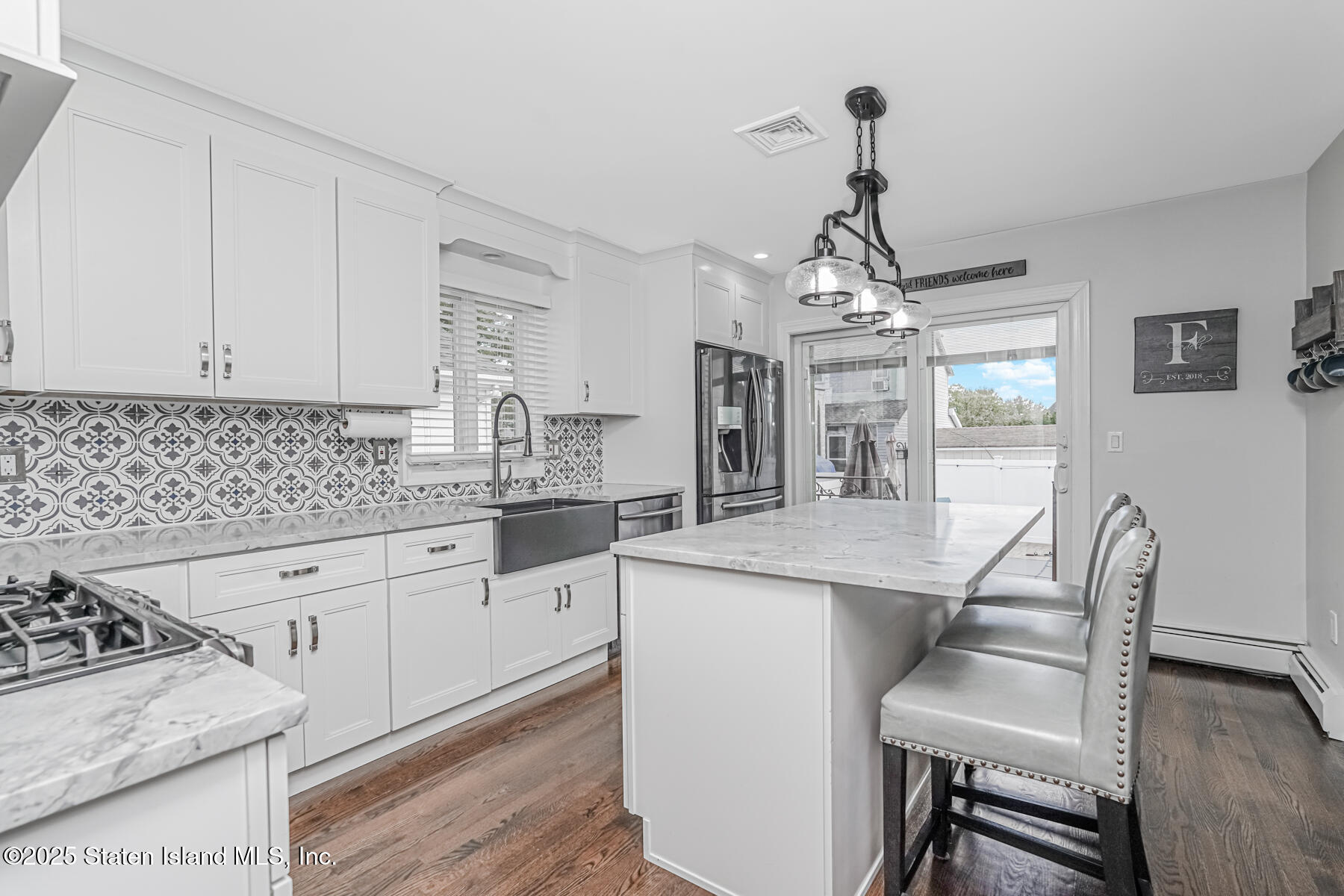 26 Rochelle Place Staten Island, NY 10312 - Photo 17 of 47 a kitchen with stainless steel appliances granite countertop a stove top oven a sink dishwasher and white cabinets with wooden floor