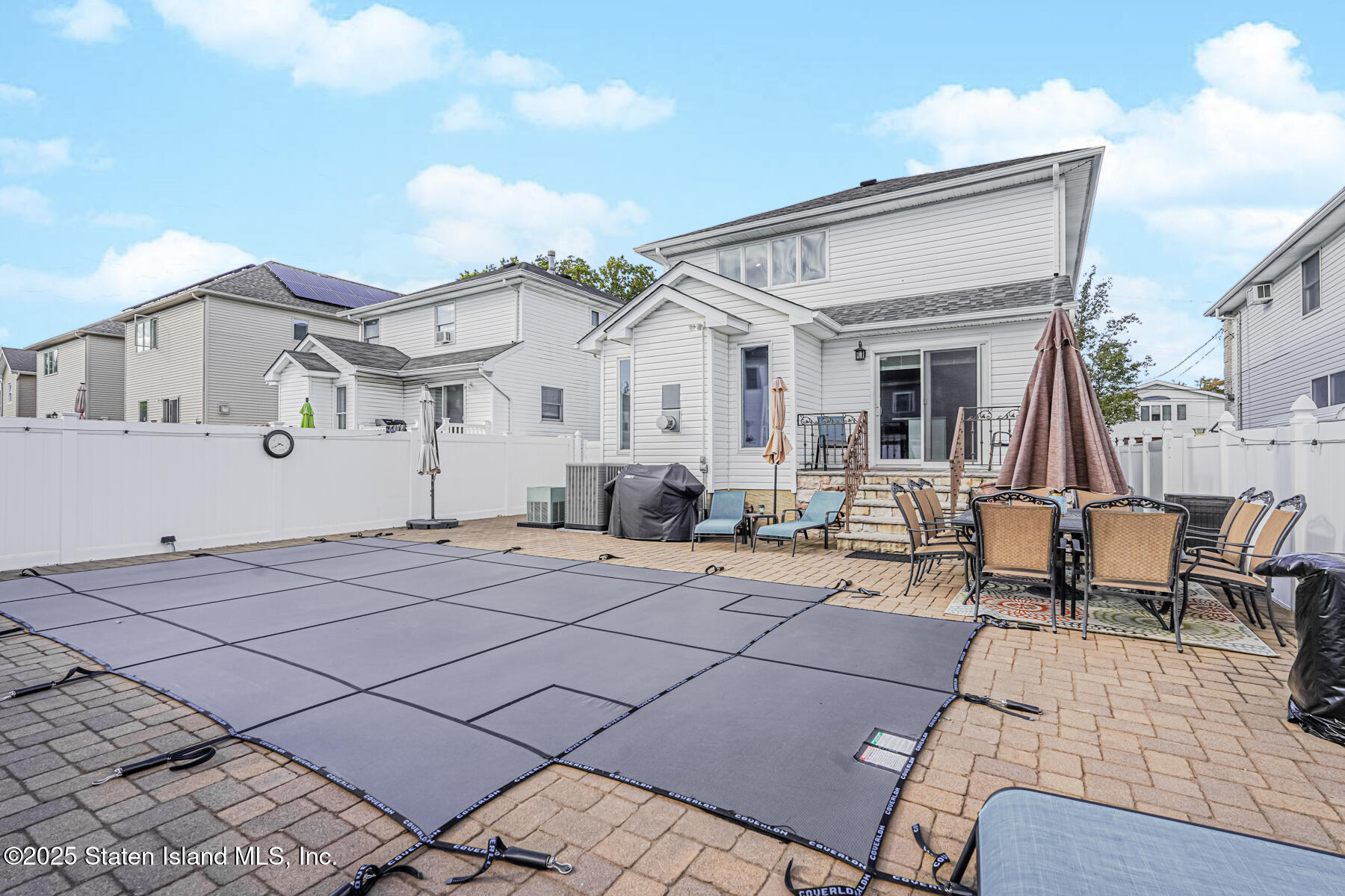 26 Rochelle Place Staten Island, NY 10312 - Photo 46 of 47 a view of a white house with many windows next to a yard
