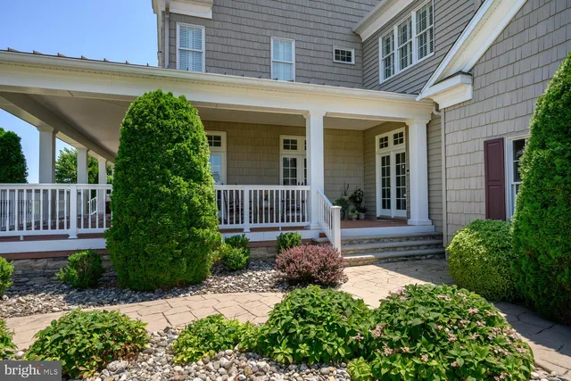 a view of a kitchen with stainless steel appliances granite countertop a stove top oven a chimney cabinets and wooden floor