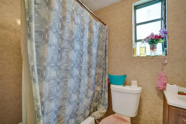 a bathroom with a toilet and a shower curtain