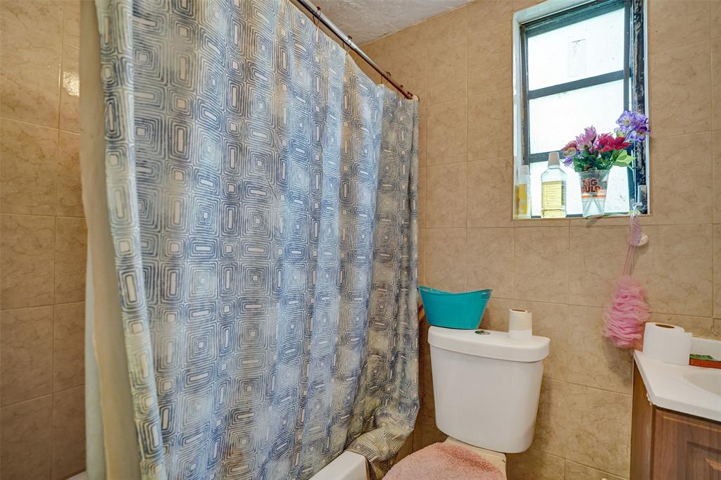 57 Northwest 68th Street Miami, FL 33150 - Photo 11 of 36 a bathroom with a toilet and a shower curtain