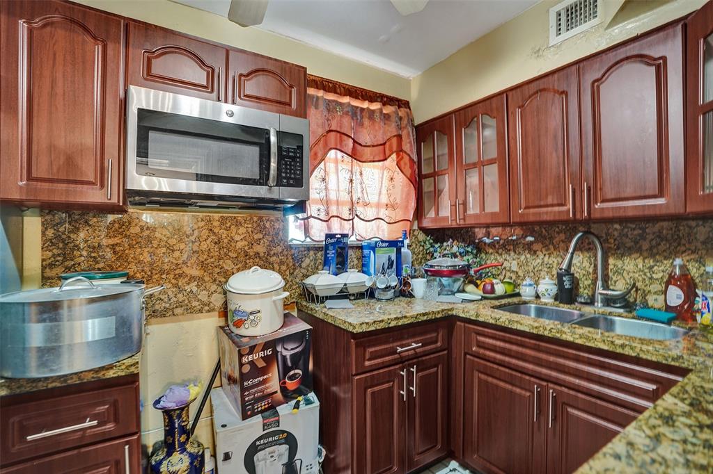 57 Northwest 68th Street Miami, FL 33150 - Photo 19 of 36 a kitchen with stainless steel appliances granite countertop a stove and a microwave