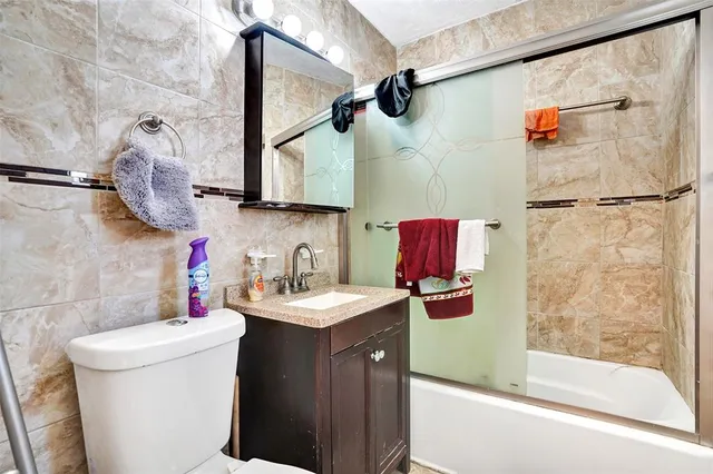 a bathroom with a sink vanity mirror and toilet