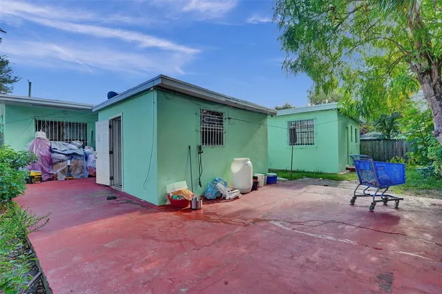 a view of a chair and table in backyard of the house