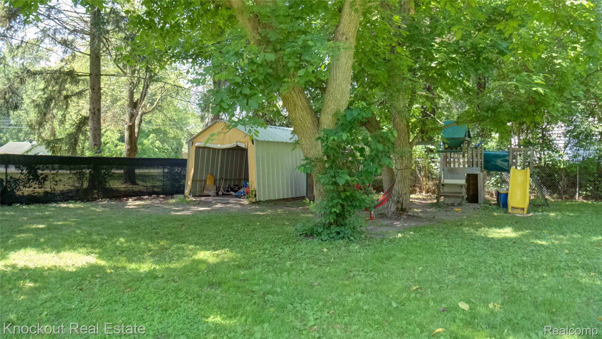 4195 Williamson Road Saginaw, MI 48601 - Photo 43 of 50 Expansive green lawn with established trees and a privacy fence