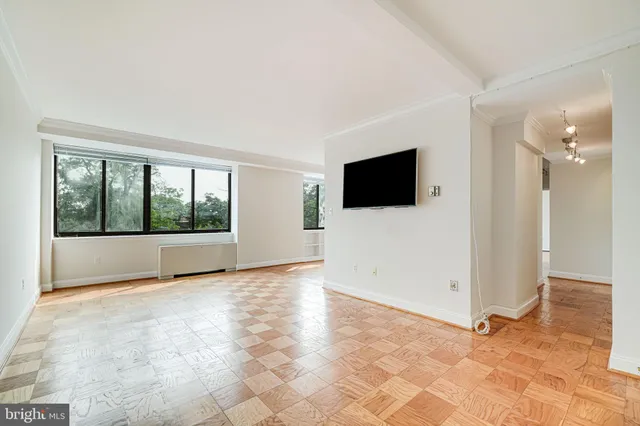 a view of an empty room with a window and a flat screen tv