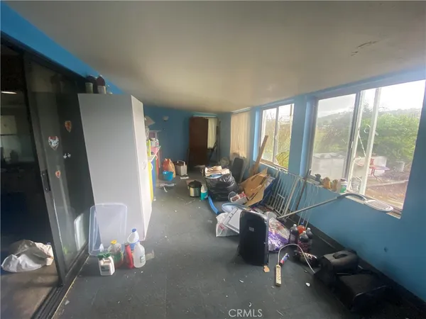 a living room with furniture a large window and gym equipment