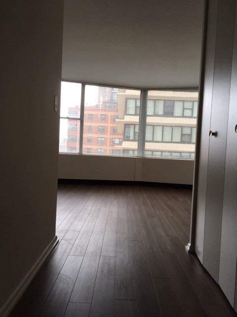 5757 North Sheridan Road, Unit 9G Chicago, IL 60660 - Photo 5 of 16 en empty room with wooden floor and windows