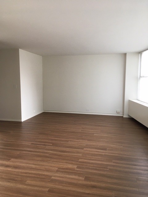 5757 North Sheridan Road, Unit 9G Chicago, IL 60660 - Photo 6 of 16 a view of an empty room with wooden floor and a window