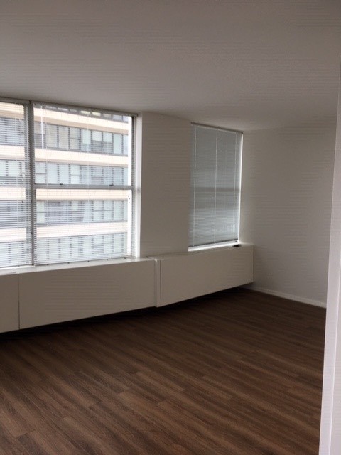 5757 North Sheridan Road, Unit 9G Chicago, IL 60660 - Photo 7 of 16 a view of an empty room with wooden floor and a window
