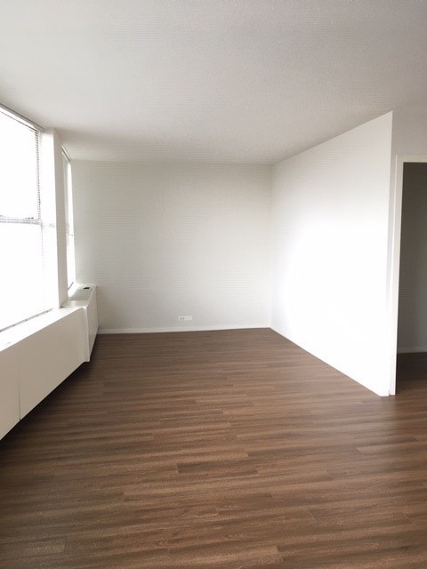 5757 North Sheridan Road, Unit 9G Chicago, IL 60660 - Photo 8 of 16 a view of an empty room with wooden floor and a window