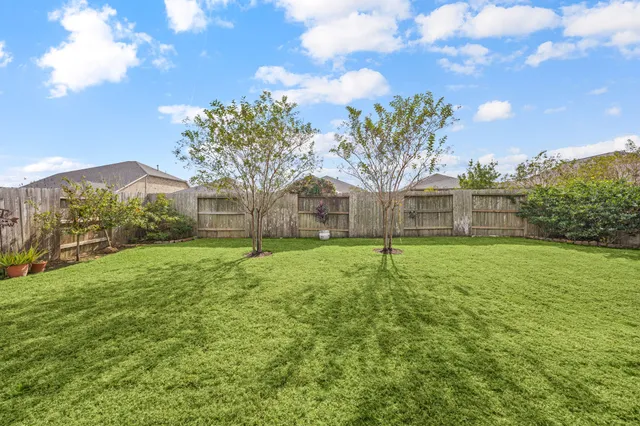a view of a house with backyard and a tree