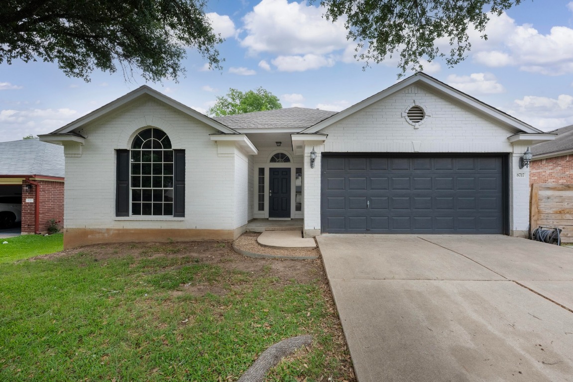 a front view of a house with yard and garage