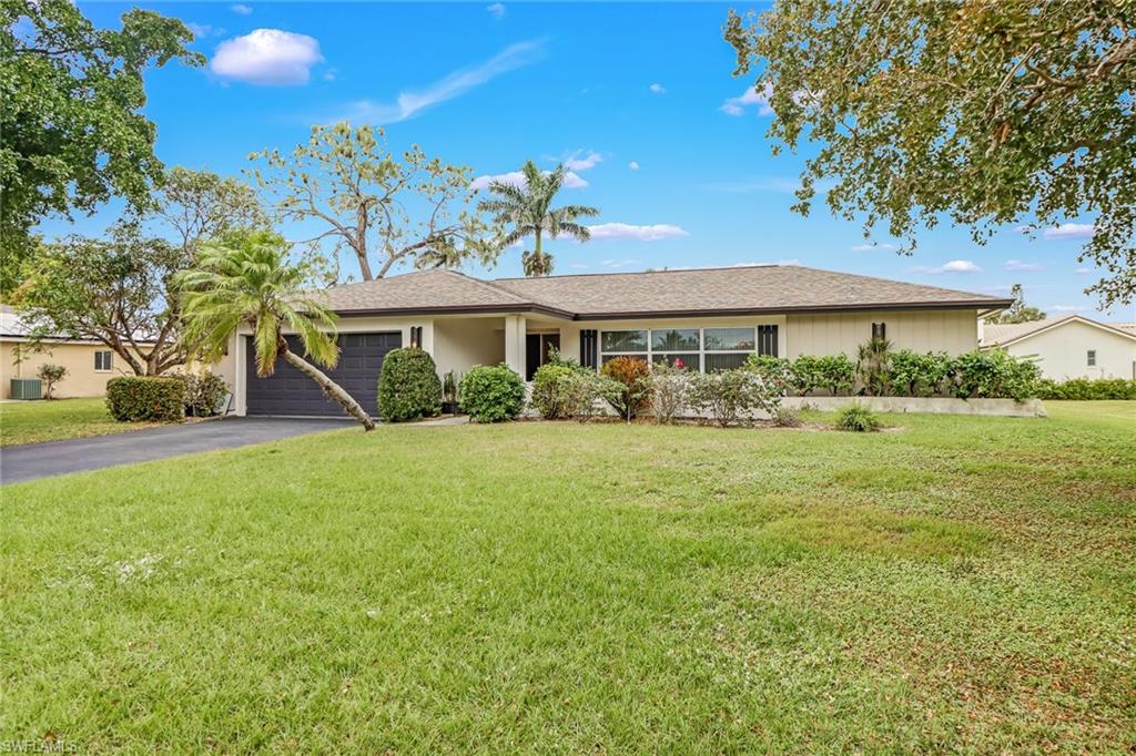 355 Valley Stream Circle Naples, FL 34113 - Photo 1 of 31 a front view of a house with a yard