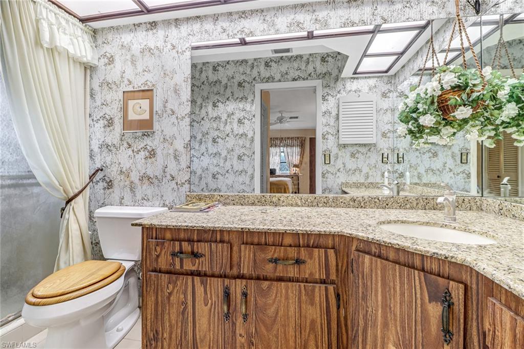 355 Valley Stream Circle Naples, FL 34113 - Photo 16 of 31 a bathroom with a granite countertop sink toilet and shower