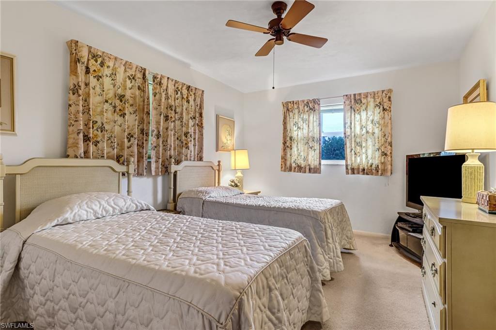 355 Valley Stream Circle Naples, FL 34113 - Photo 18 of 31 a bedroom with a bed window and a flat screen tv