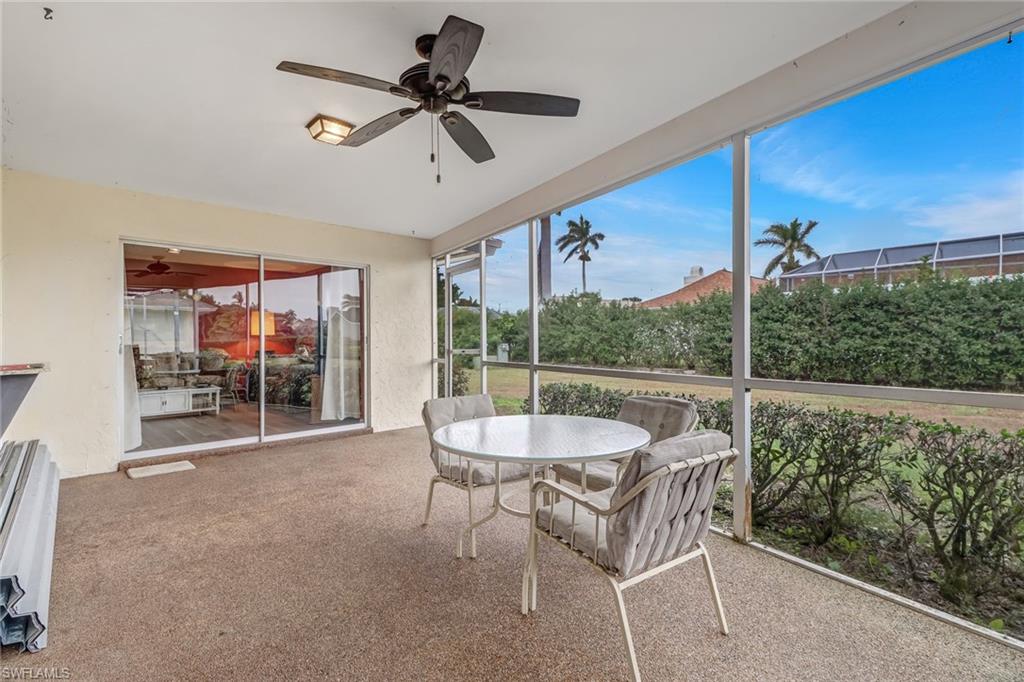 355 Valley Stream Circle Naples, FL 34113 - Photo 23 of 31 a dining room with furniture a chandelier and a floor to ceiling window