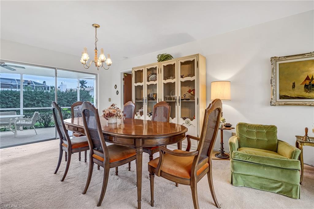 355 Valley Stream Circle Naples, FL 34113 - Photo 6 of 31 a view of a dining room with furniture wooden floor and chandelier