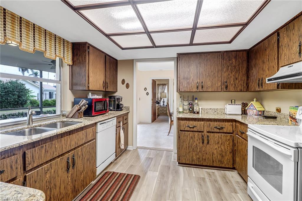 355 Valley Stream Circle Naples, FL 34113 - Photo 7 of 31 a kitchen with sink cabinets and window